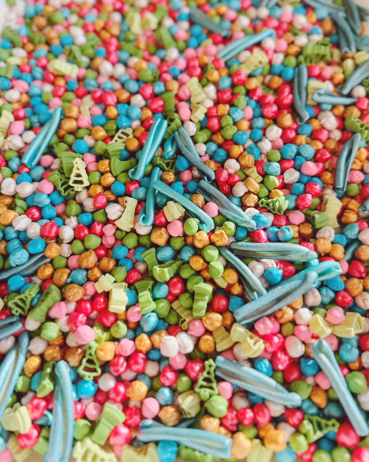 Detail of Forest Jamboree filler with metallic blue pasta, green trees and pearly red beads