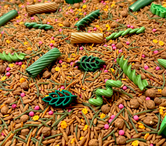 Close-up of Acorn Hollow woodland filler with brown rice, green leaf pasta and pink flower sprinkles
