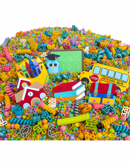 Kool School sensory bin with school bus, schoolhouse, books and chalkboard pieces in pastel filler