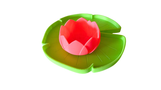 Pink lotus flower toy on a green lily pad play tray